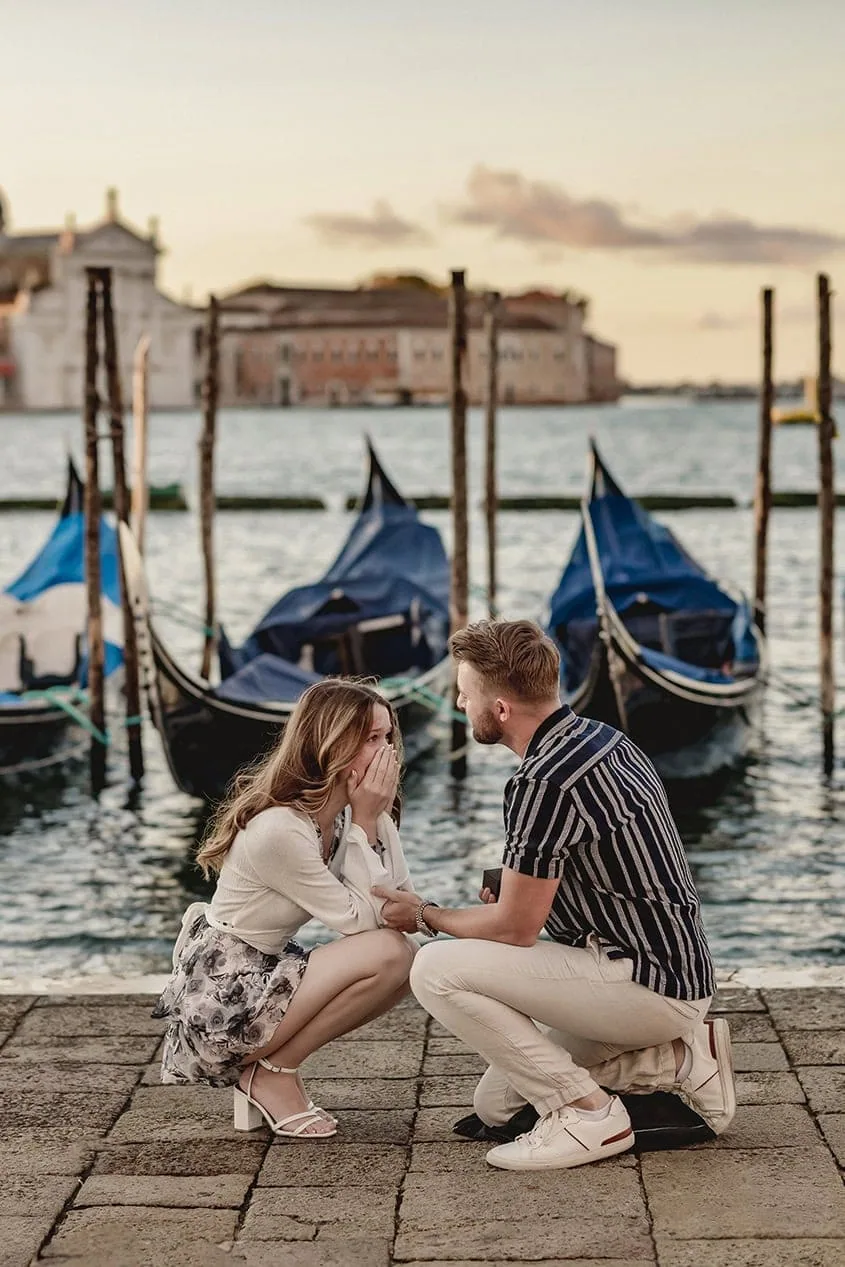 A man on one knee proposing on the Riva degli Schiavoni, with views of the Grand Canal – best proposal Venice moment.