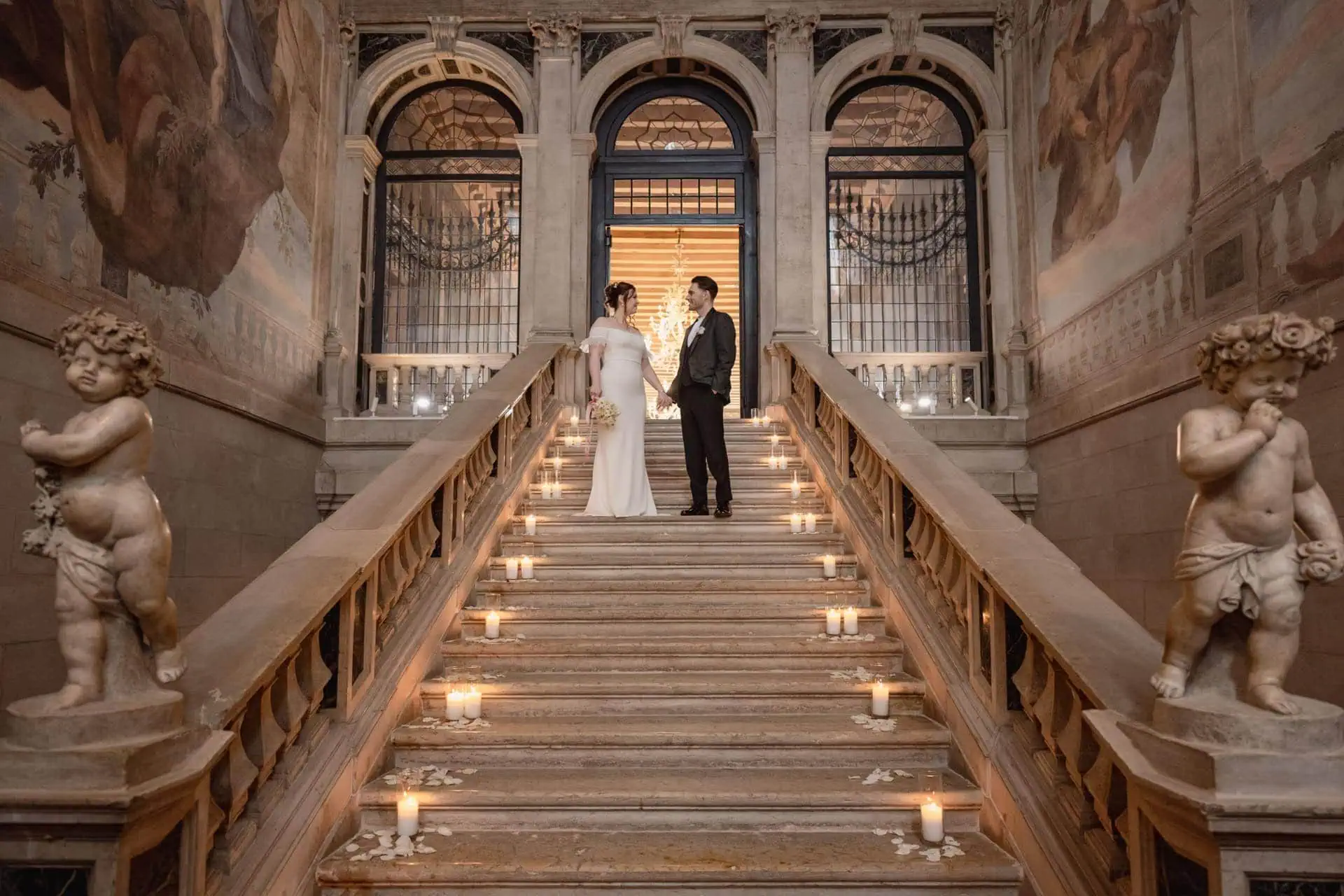 Bride and groom on the grand staircase of Ca’ Sagredo for wedding photos in Venice