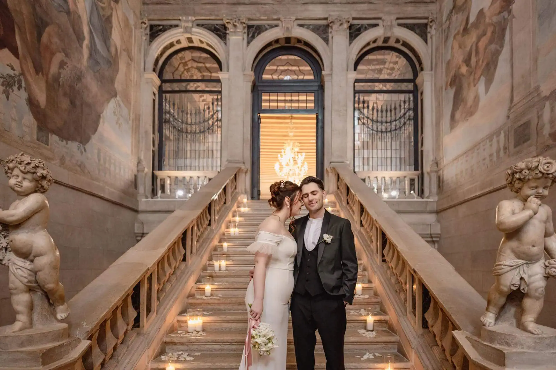 Bride and groom on the grand staircase of Ca’ Sagredo for wedding photos in Venice