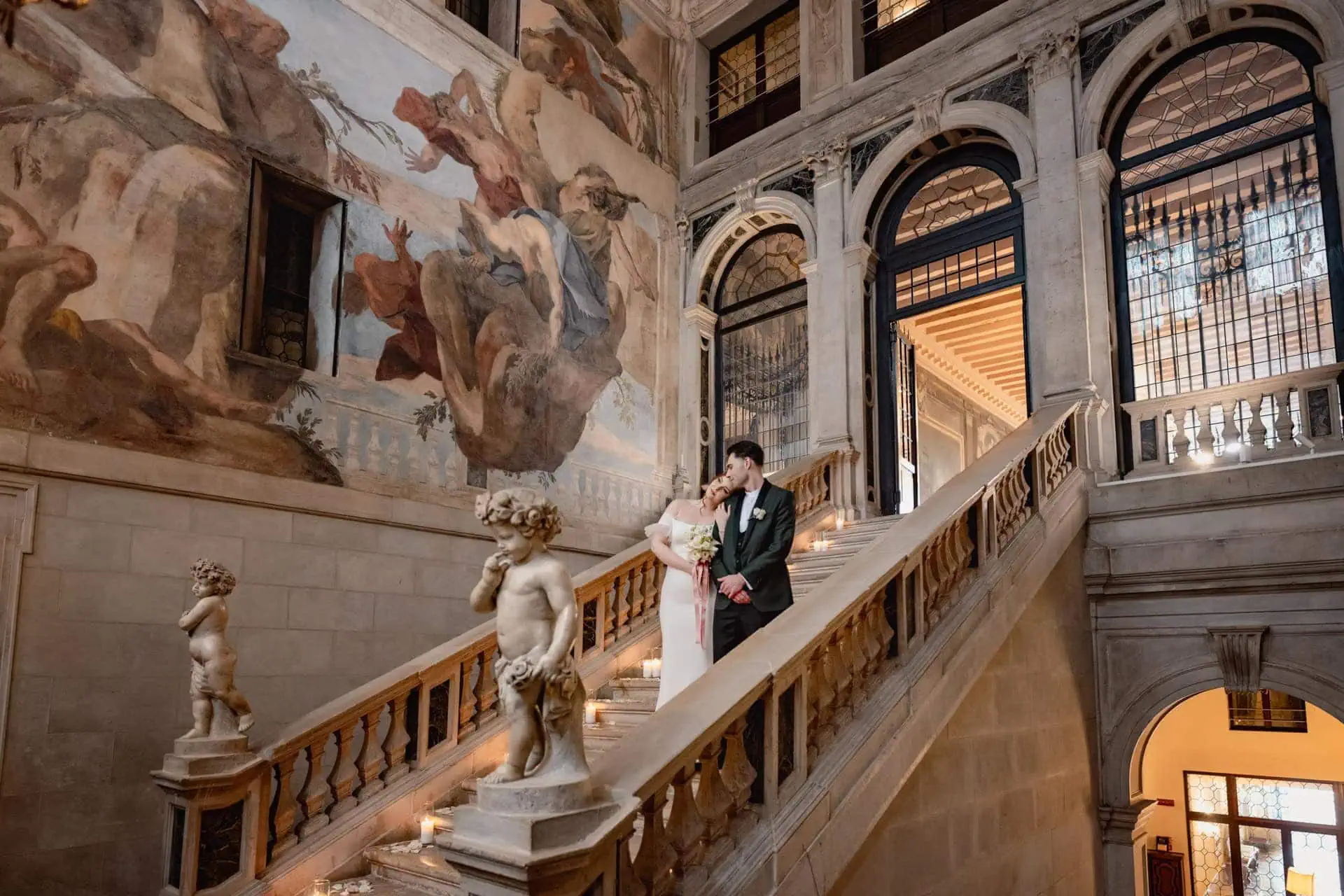 Bride and groom on the grand staircase of Ca’ Sagredo for wedding photos in Venice