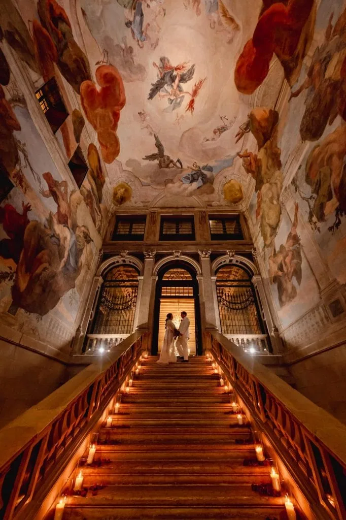 A couple posing Couple enjoying Venice photography services on the grand staircase of Ca' Sagredo – elopement photography Venice.