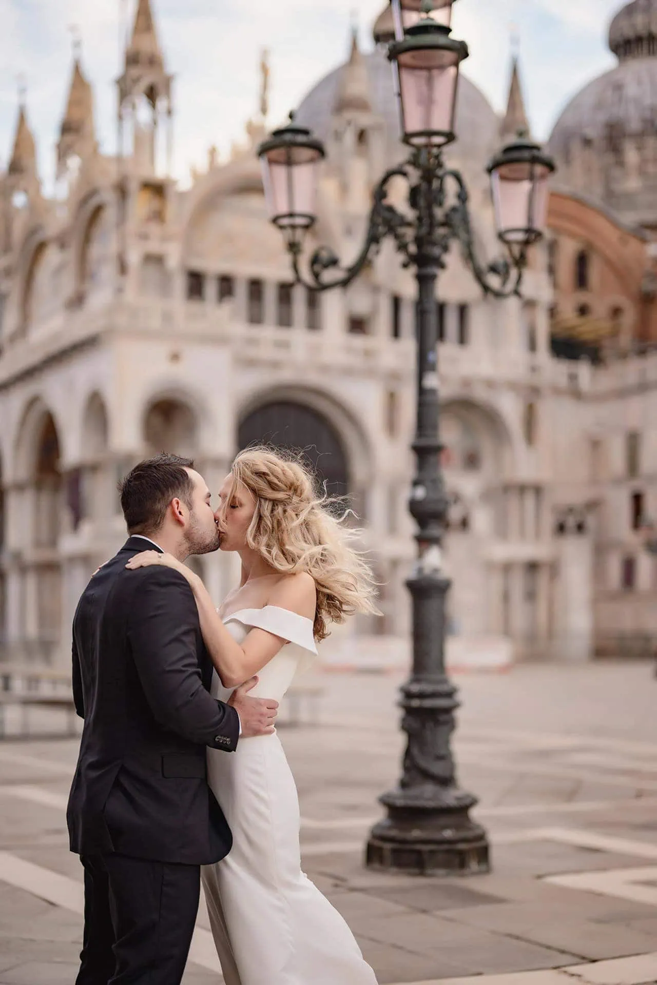 Couple sharing a kiss in front of St. Mark’s Basilica in Venice – Venice Wedding Photography Engagement.