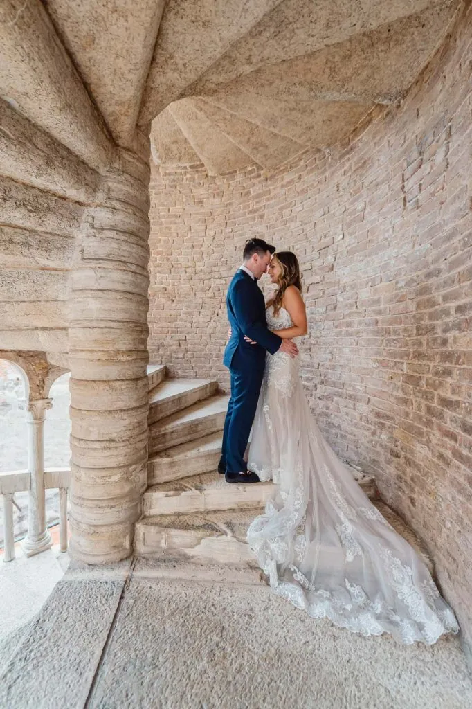 Couple embracing on the spiral staircase of Scala Contarini del Bovolo – Venice Wedding Photography Engagement.