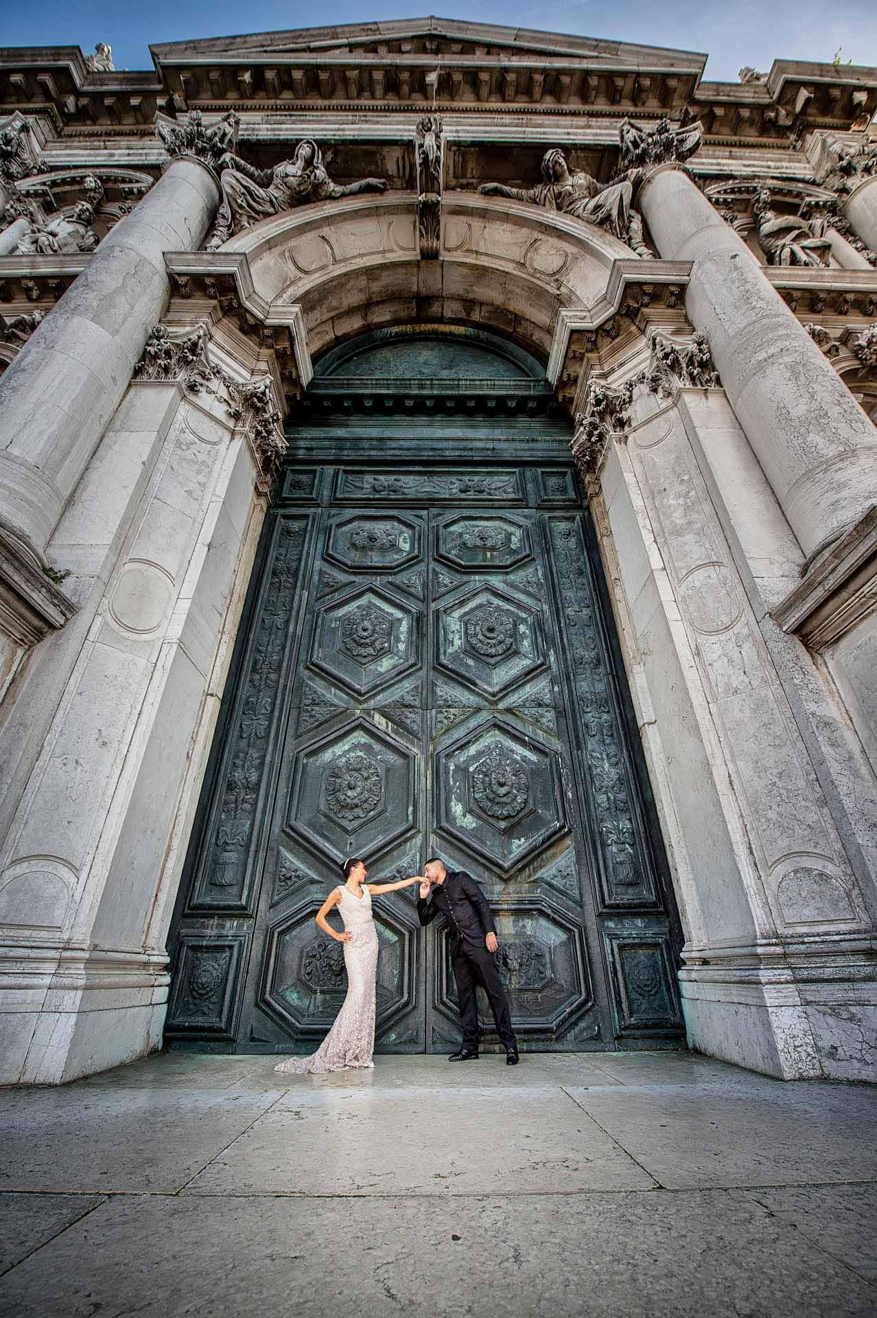 Couple posing at the grand entrance of Santa Maria della Salute in Venice – Venice Wedding Photography Engagement