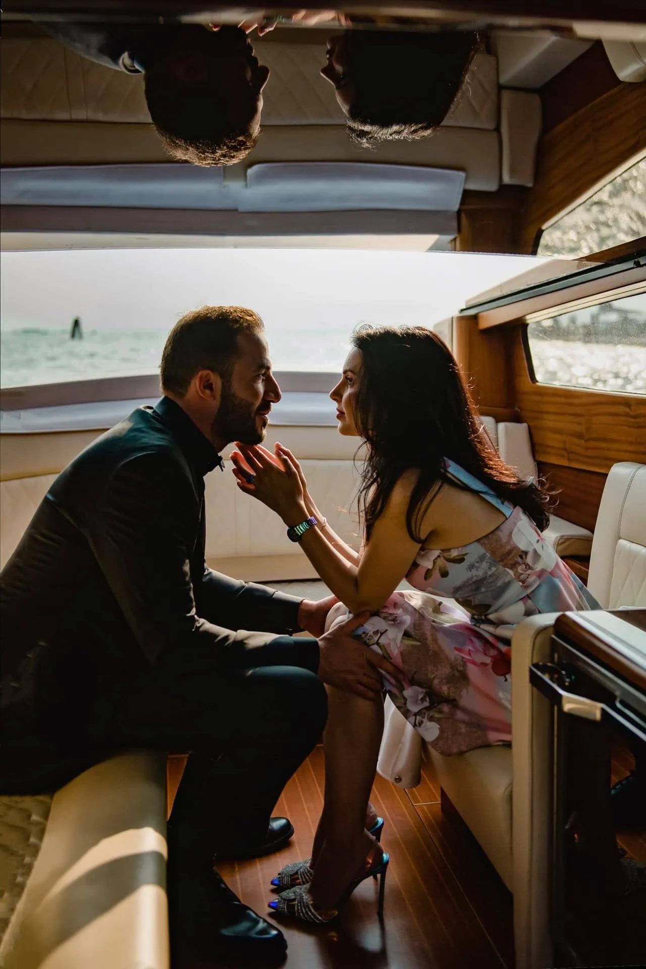Couple enjoying Venice wedding photography in a boat taxi at sunset with the Basilica di Santa Maria della Salute in the background – proposal photography Venice.