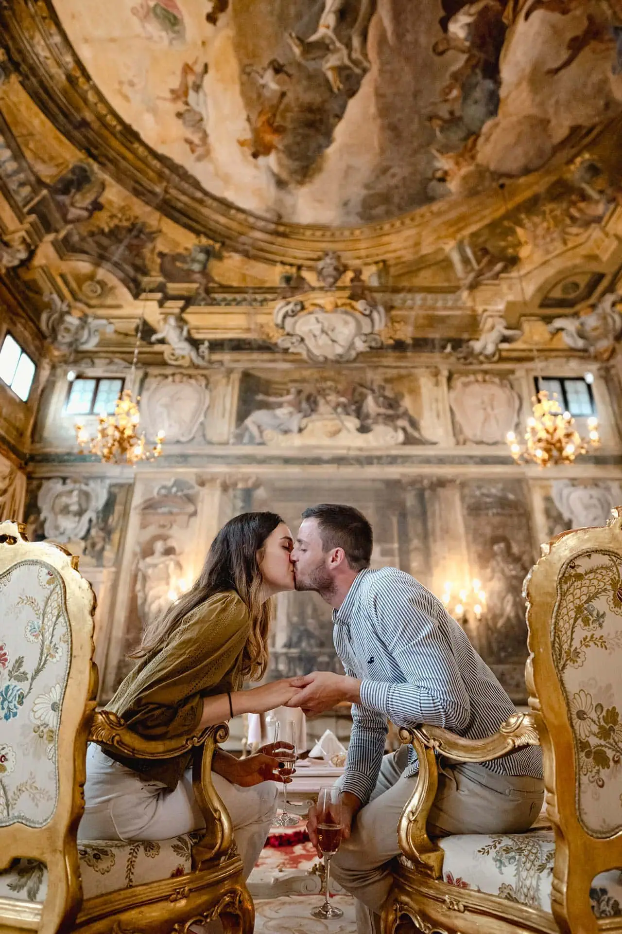 A couple kissing in the grand music hall of Ca' Sagredo Palace in Venice – proposal photography Venice.