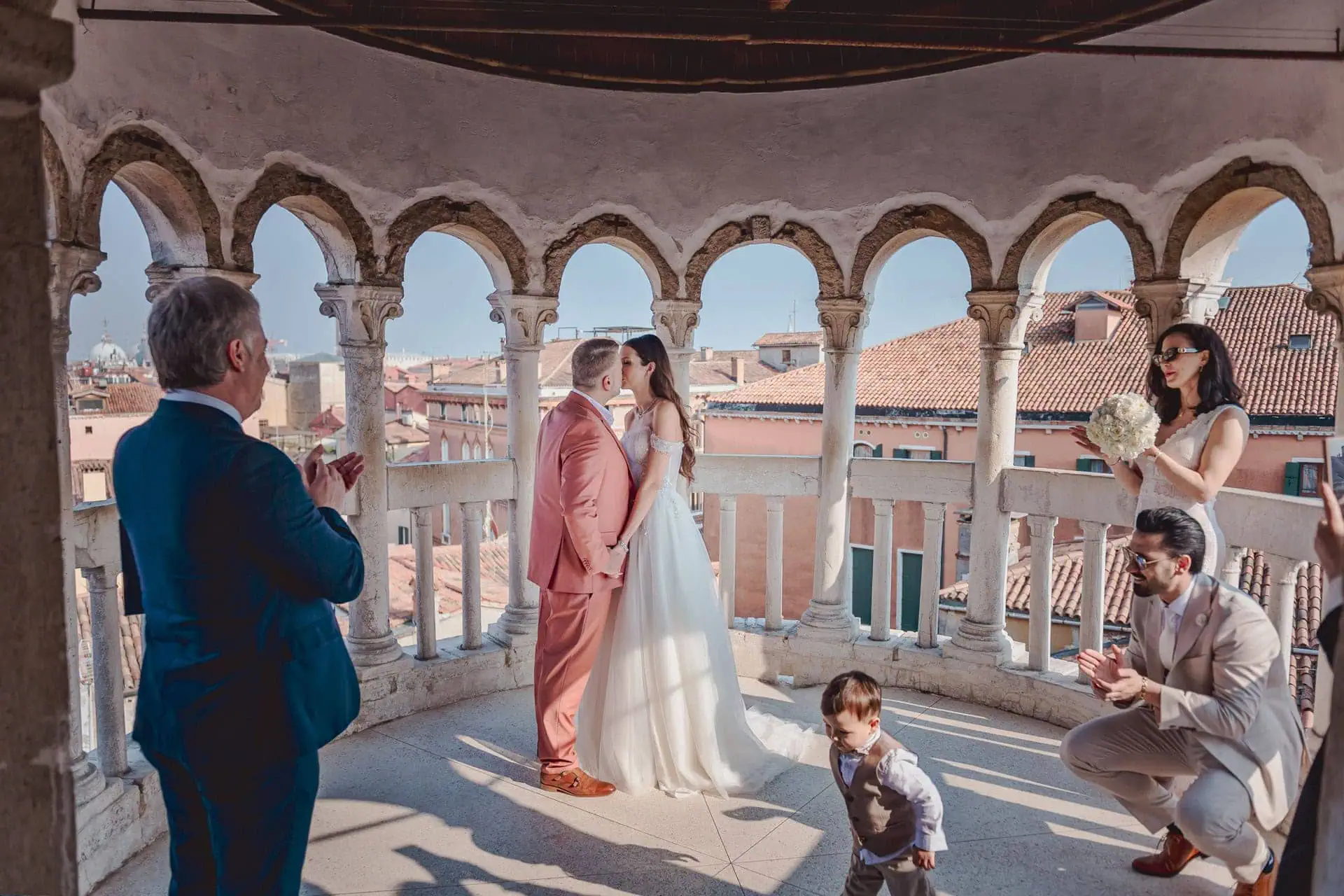 Venice wedding proposal under historic archways with city rooftops in the background.