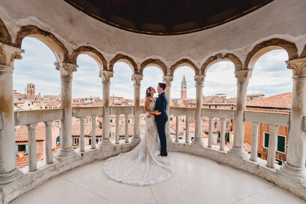 Bride and groom pose on the spiral staircase of Scala Contarini del Bovolo in Venice.