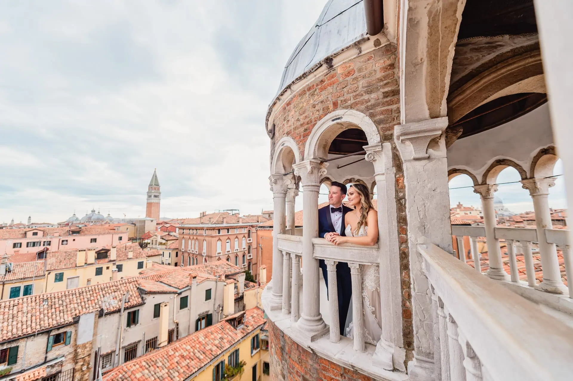Bride and groom pose on the spiral staircase of Scala Contarini del Bovolo in Venice.