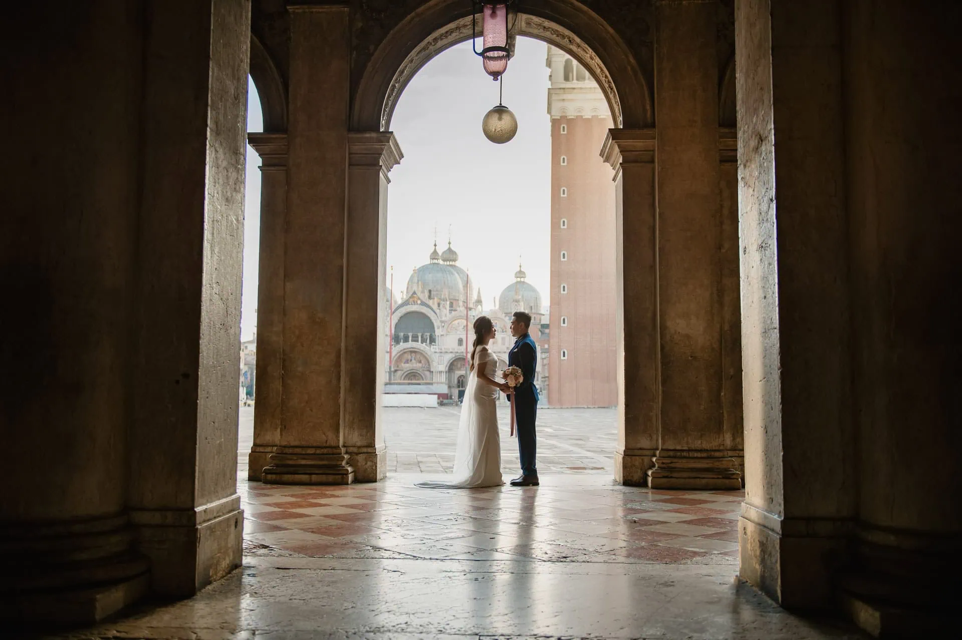 Happy couple celebrating engagement in front of the Basilica di San Marco – Venice proposal photographer.