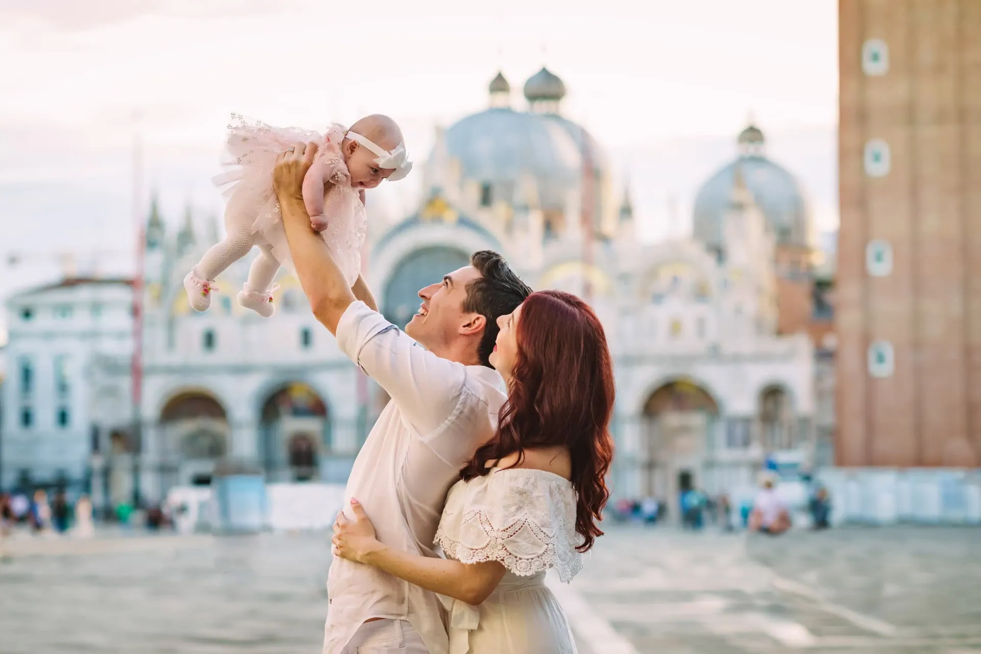Happy couple celebrating engagement in front of the Basilica di San Marco – Venice proposal photographer.