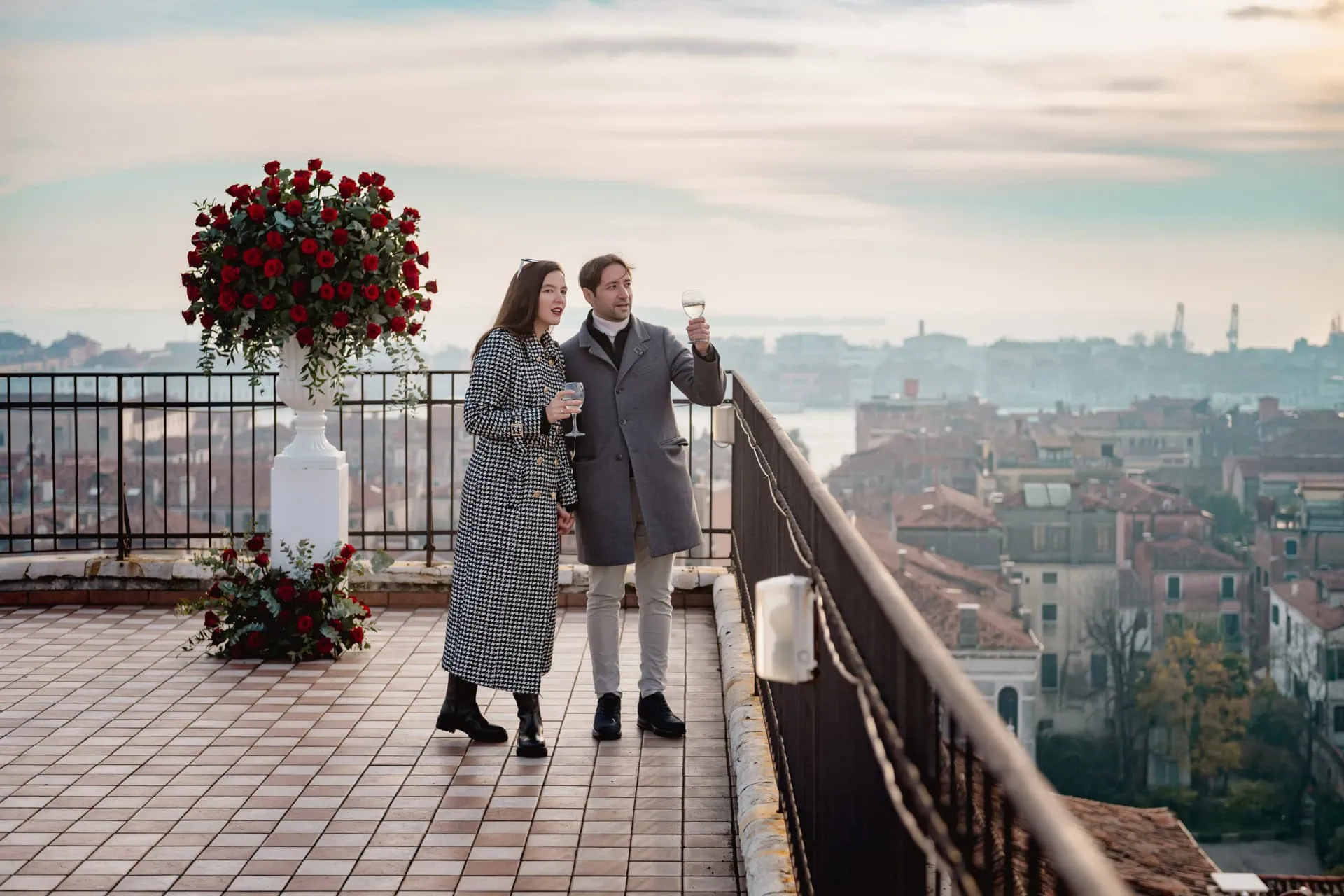 A couple celebrating their engagement on the balcony of NH Dei Dogi in Venice – proposal photography Venice.