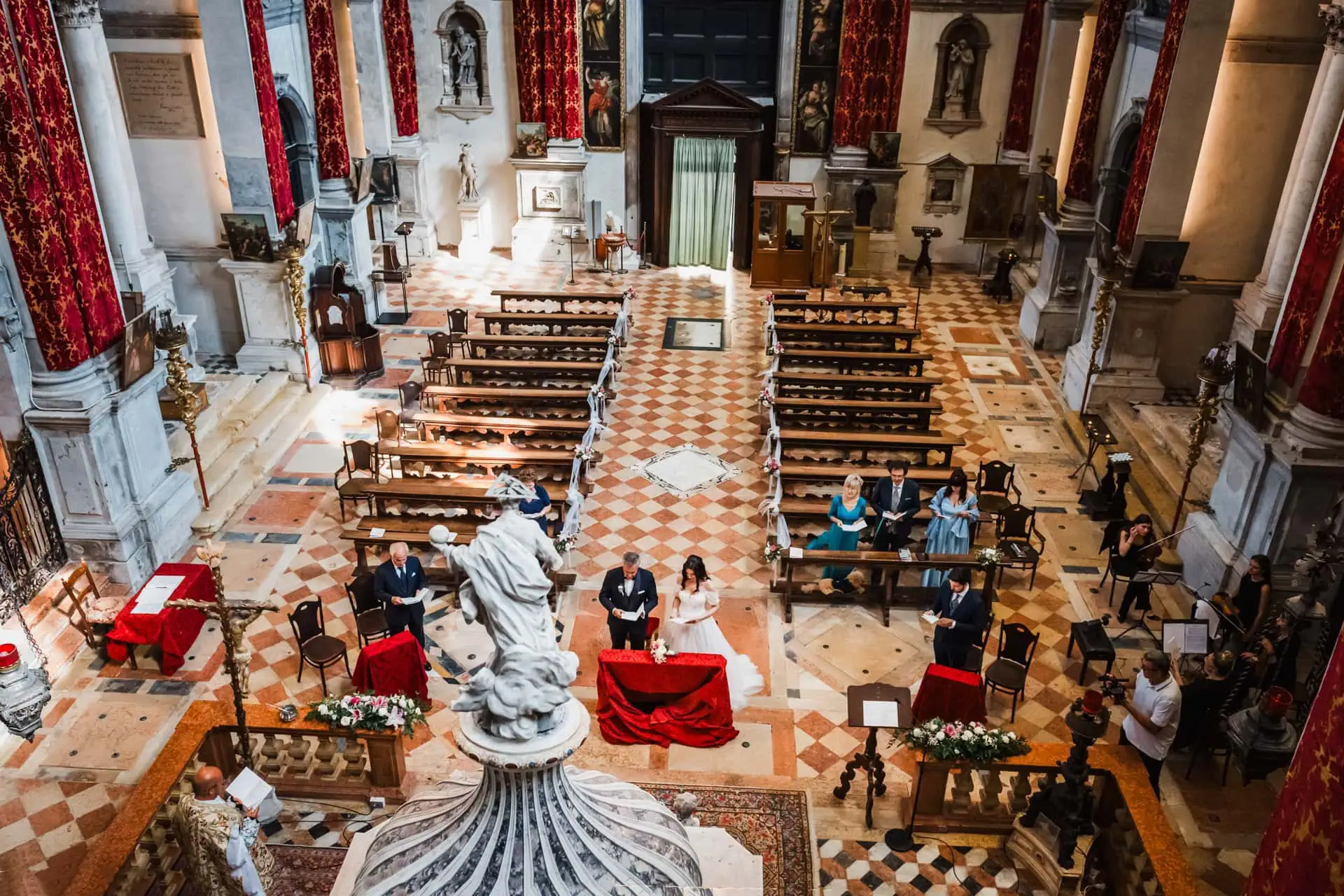 Venice wedding ceremony inside historic church with ornate decor and altar.