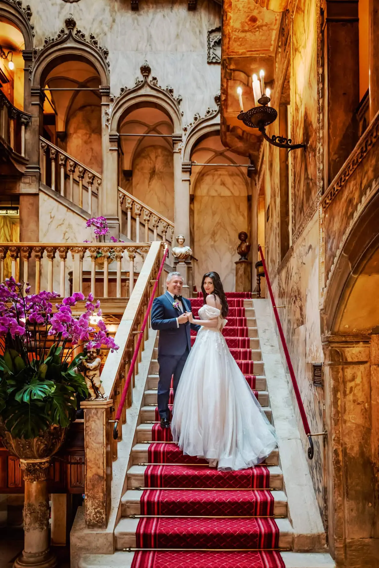 Elegant wedding couple on ornate staircase inside historic Venice palace for wedding, proposal, engagement photography.