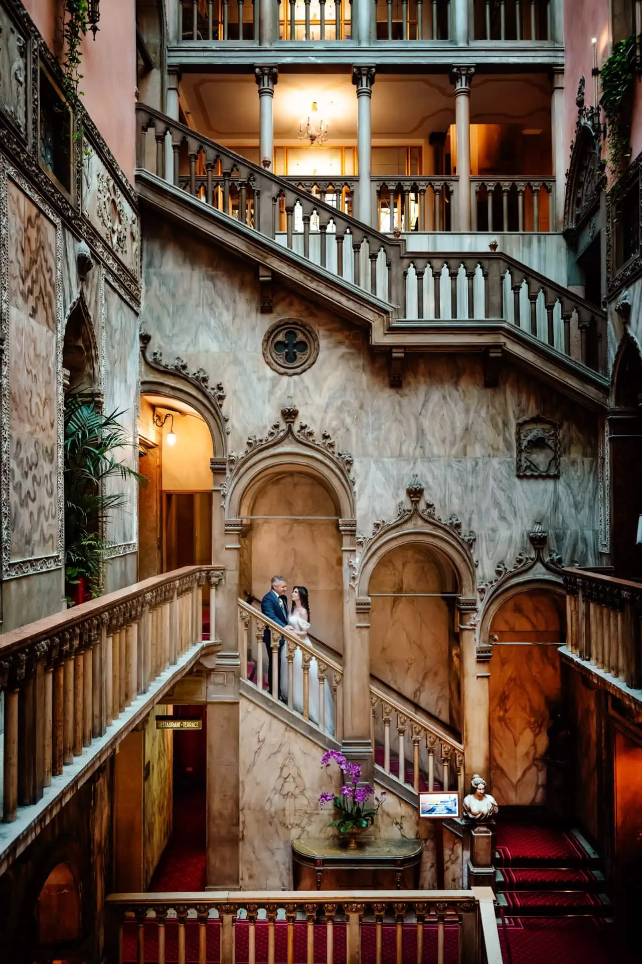 Venice wedding couple on historic staircase in luxurious interior setting.