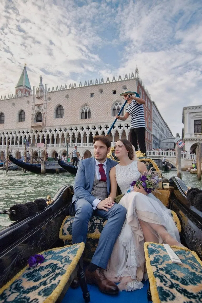 Wedding photography Venice - Couple in gondola in front of Church of Miracoli