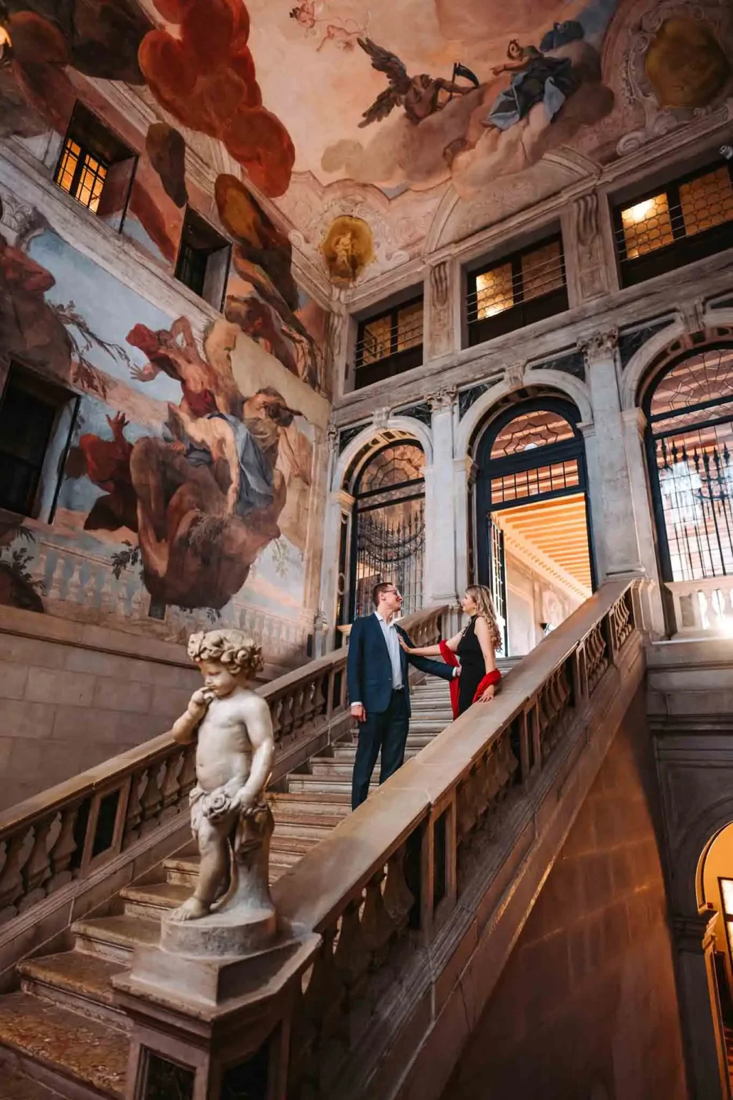Couple posing on grand staircase.