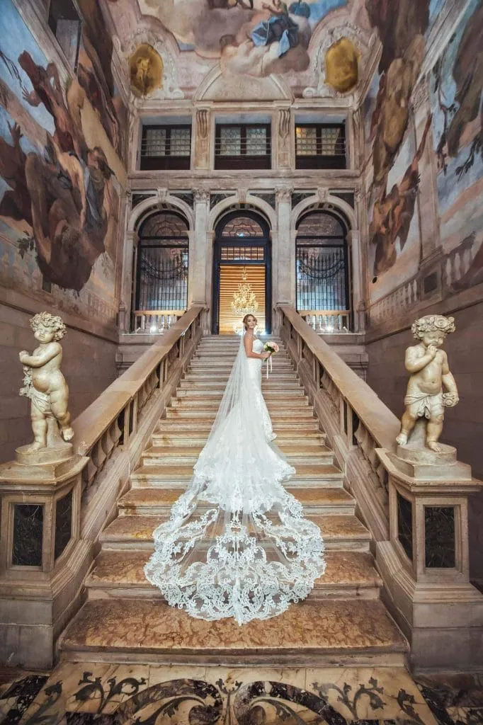 A couple during a symbolic wedding in Venice captured inside a luxurious private palace, surrounded by elegant decor.