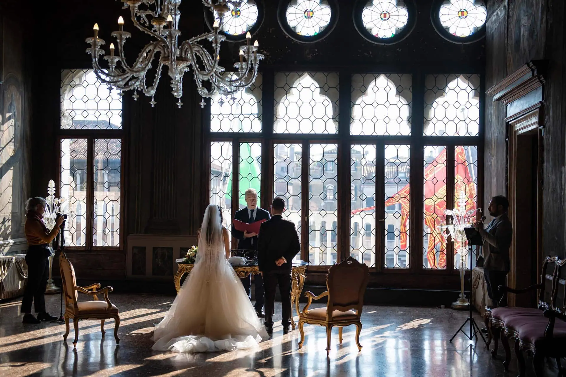 A couple during a symbolic wedding in Venice captured inside a luxurious private palace, surrounded by elegant decor.