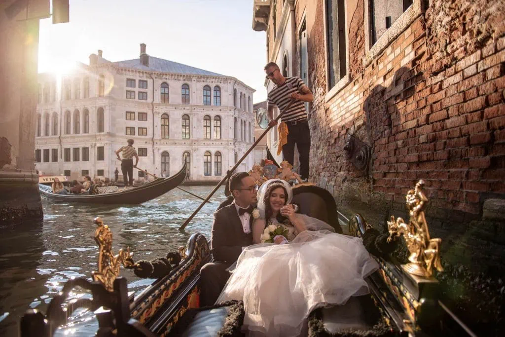 A couple during a symbolic wedding in Venice captured in a romantic gondola ride on the Grand Canal.