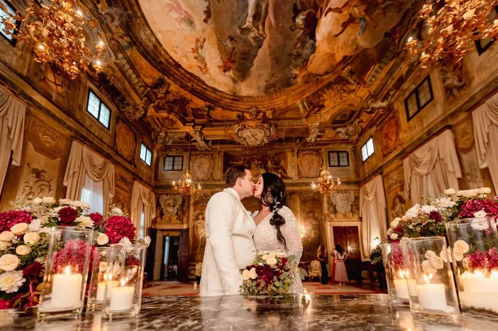 A couple during a symbolic wedding in Venice captured inside a luxurious private palace, surrounded by elegant decor.