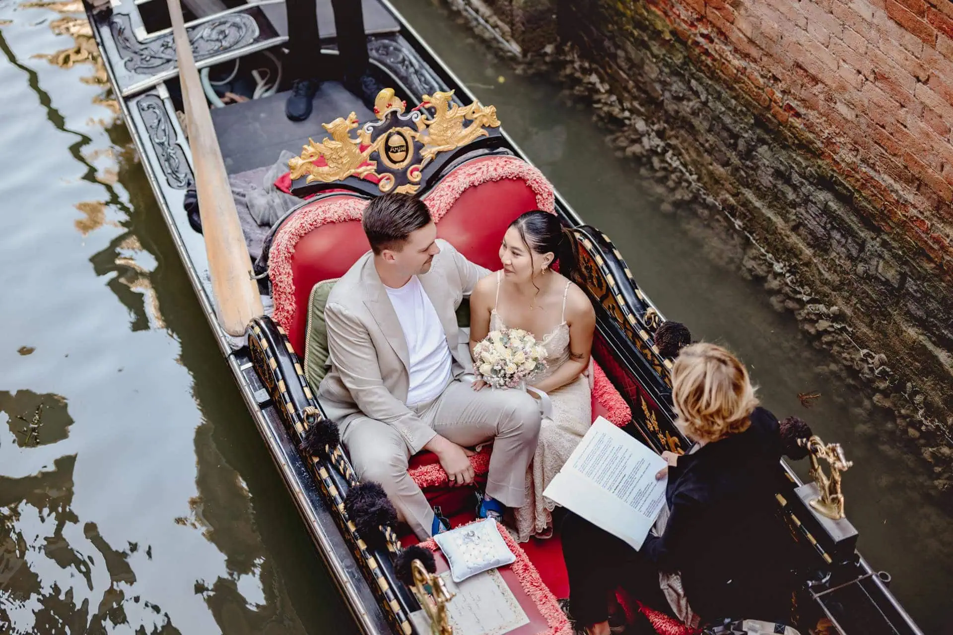 A couple during a symbolic wedding in Venice captured in a romantic gondola ride on the Grand Canal.