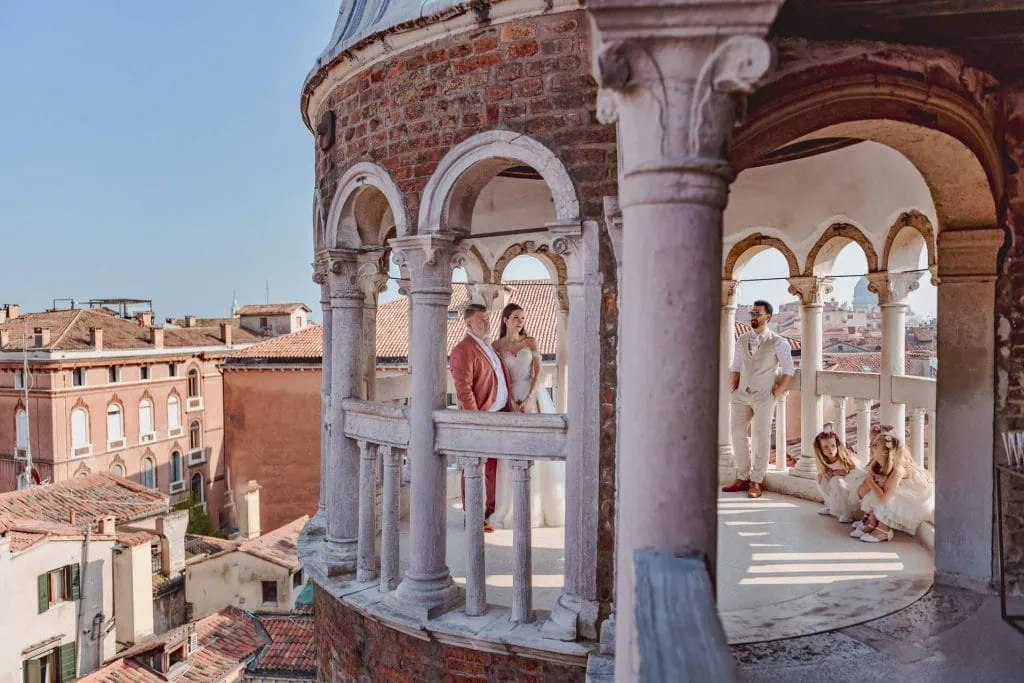 A couple during a symbolic wedding in Venice captured by a professional photographer at the stunning Contarini del Bovolo spiral staircase.