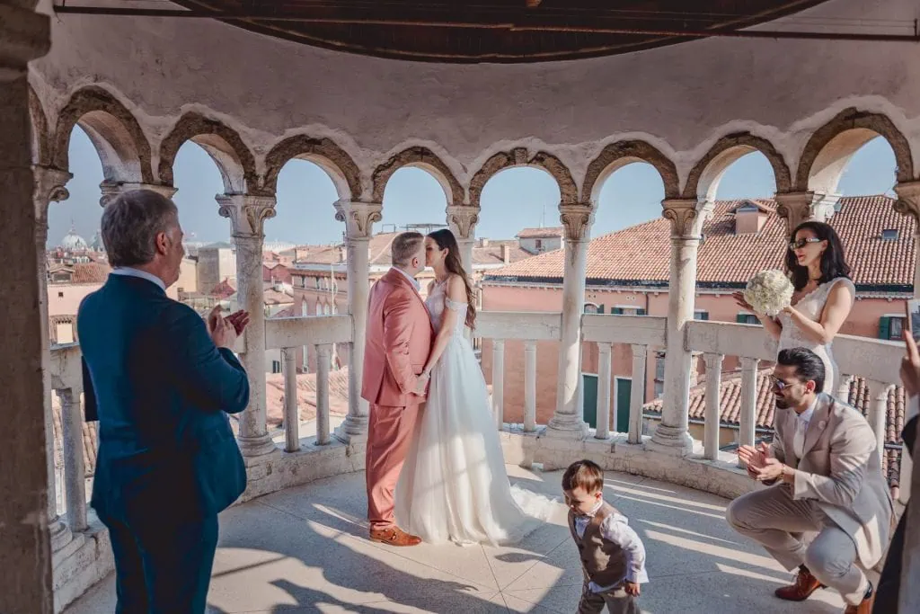 A couple during a symbolic wedding in Venice captured by a professional photographer at the stunning Contarini del Bovolo spiral staircase.
