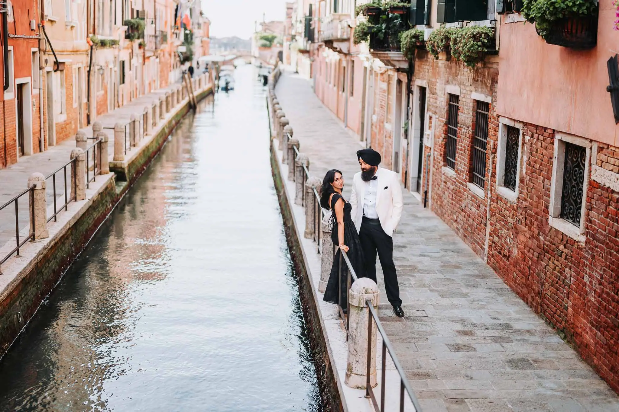 Couple by serene canal in Venice.