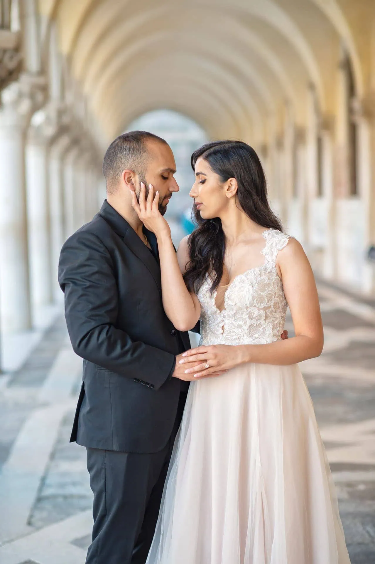 Engagement photo of a couple under the Doge’s Palace arches, a hidden gem for the best proposal Venice.