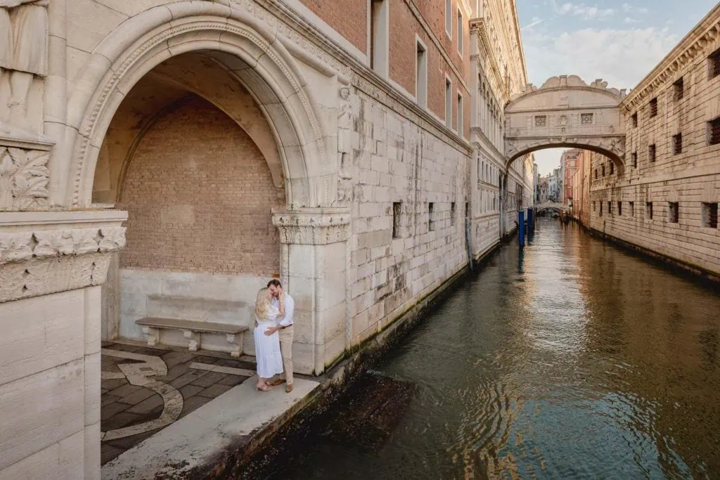Engagement photo of a couple under the Doge’s Palace arches, a hidden gem for the best proposal Venice.