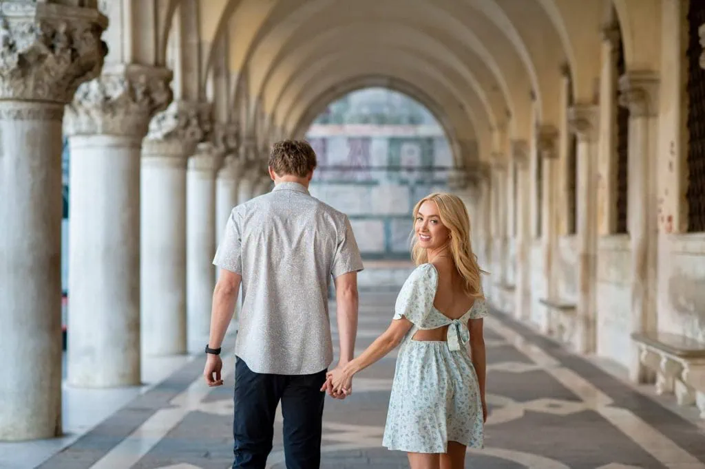 Engagement photo of a couple under the Doge’s Palace arches, a hidden gem for the best proposal Venice.