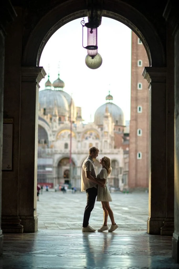 Engagement photo of a couple under the Doge’s Palace arches, a hidden gem for the best proposal Venice.
