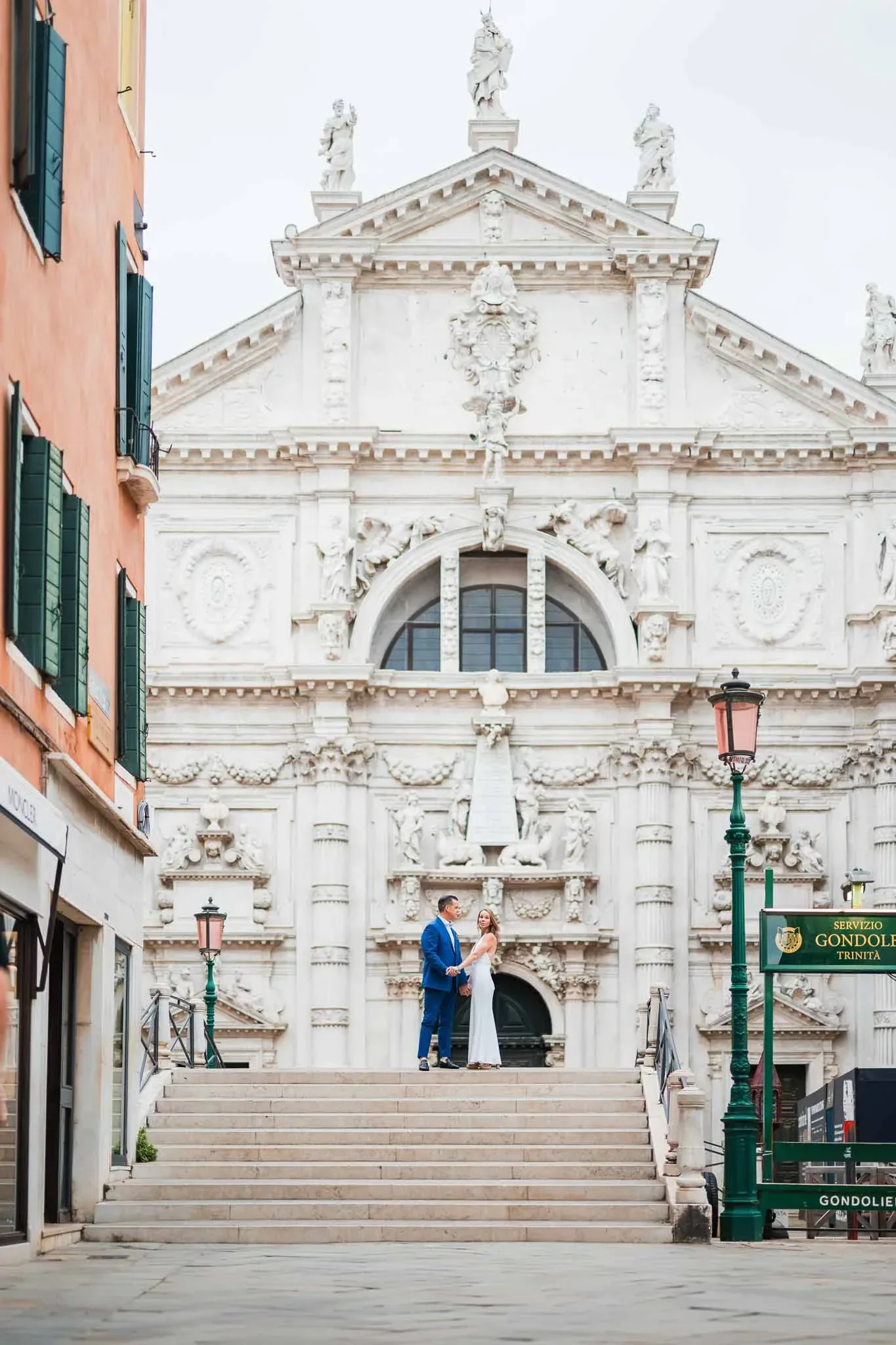 Venice wedding couple holding hands on steps in front of a historic church, romantic engagement moment.