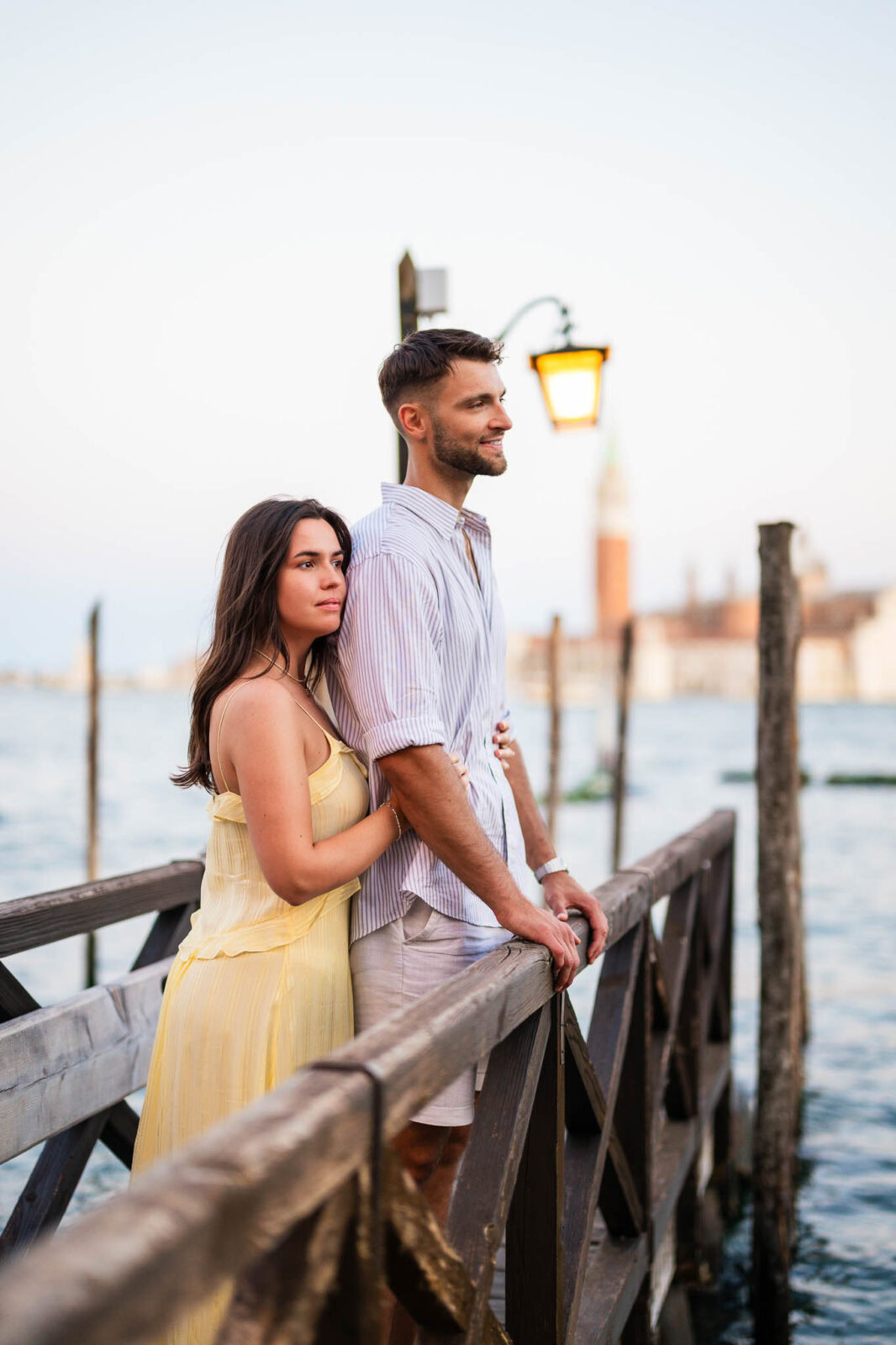Venice couple at sunset on wooden dock by water, romantic engagement photoshoot.