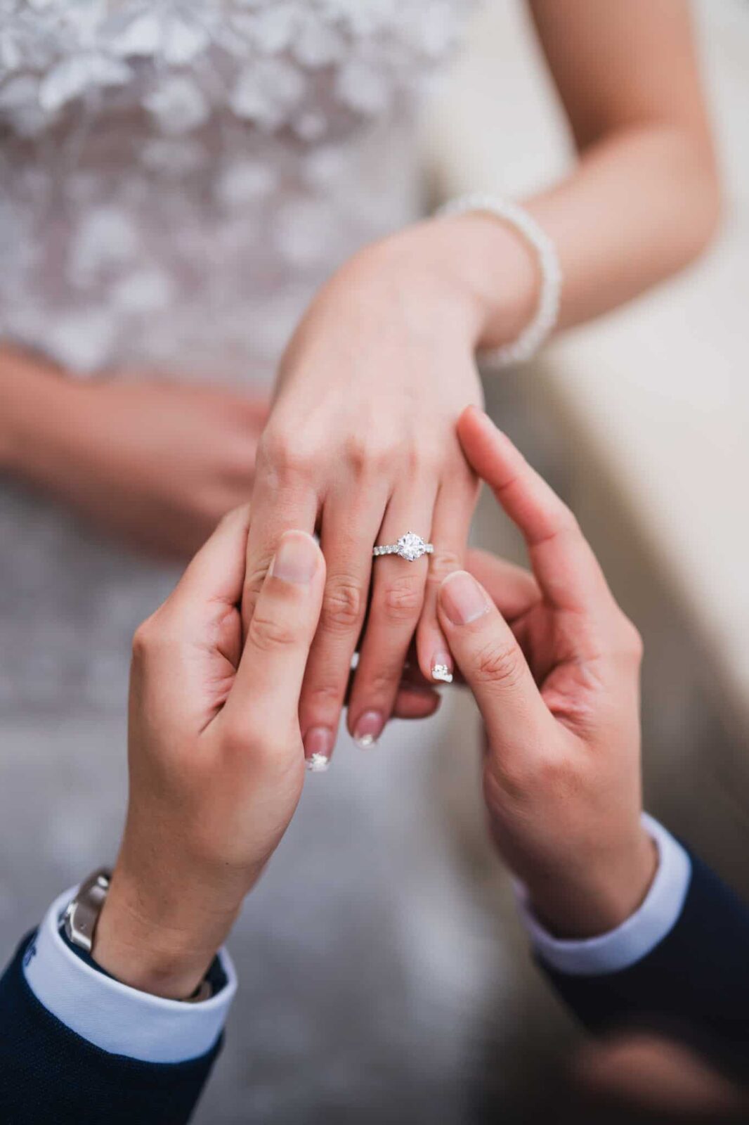 Engagement ring being placed on bride's finger at Venice wedding ceremony.