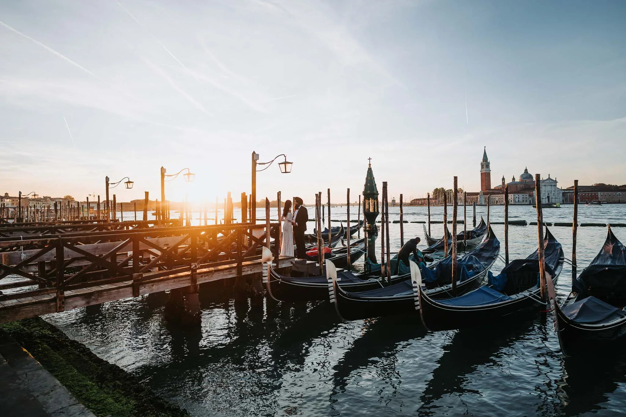 Couple by gondolas at sunset.