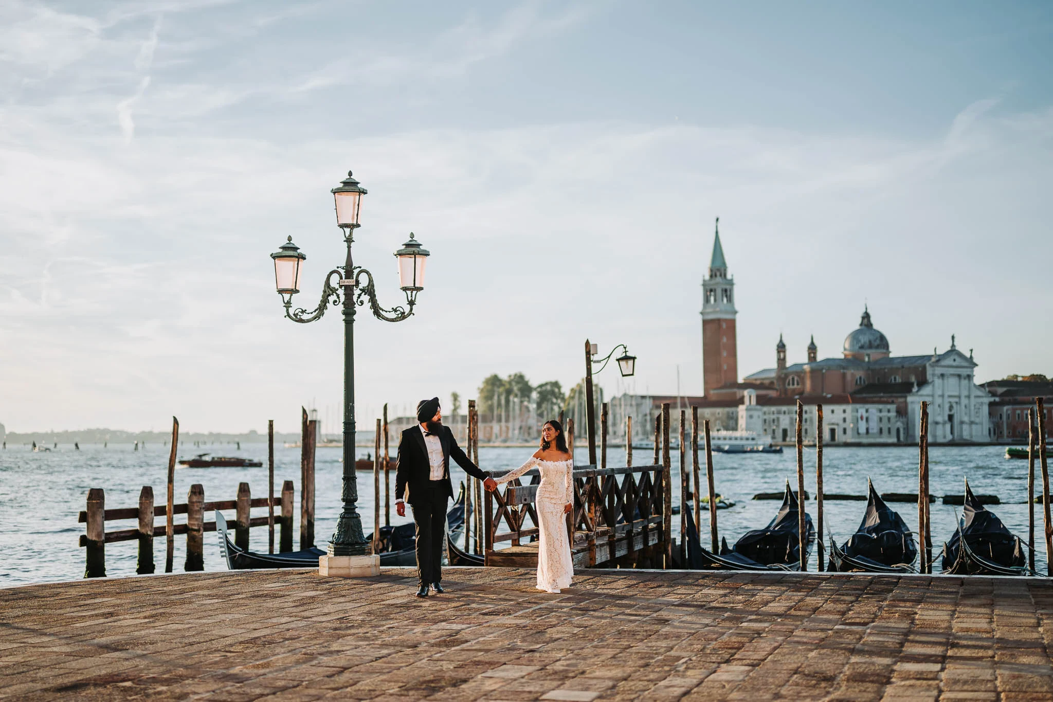 Venice wedding couple holding hands by the water, historic architecture in the background, romantic engagement photoshoot, Venice Italy.