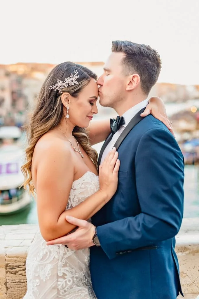 Bride and groom pose at sunrise on the empty Rialto Bridge in Venice.