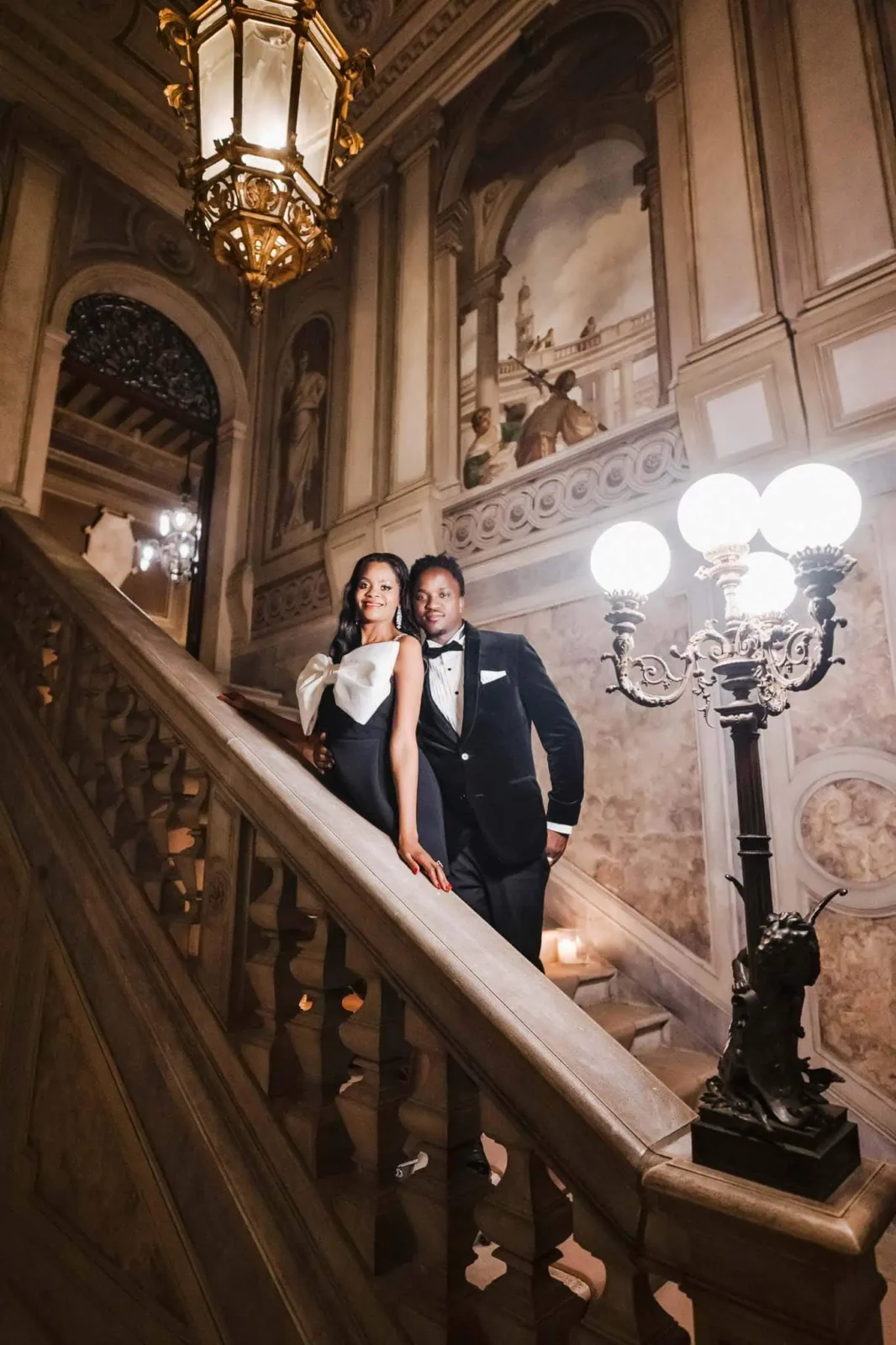 Elegant couple on grand staircase.