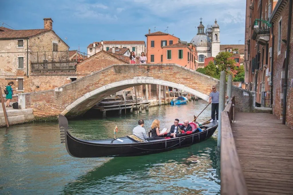 A couple during a symbolic wedding in Venice captured in a romantic gondola ride on the Grand Canal.