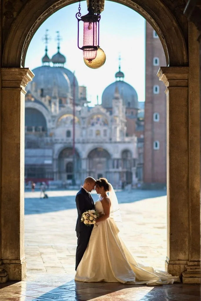 A couple during a symbolic wedding in Venice captured in the iconic Piazza San Marco, surrounded by its majestic architecture.