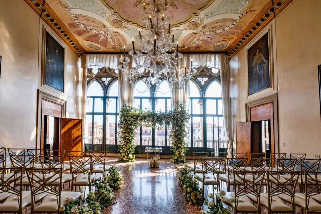 A couple during a symbolic wedding in Venice captured inside the historic Pisani Moretta palace.