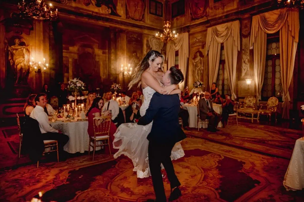 Bride and groom perform their first dance under the chandeliers of the Sala della Musica.