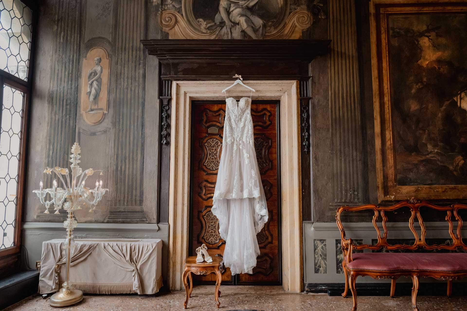 Bride and groom hold hands around a corner for their "first touch" moment in a luxurious Venetian hotel.