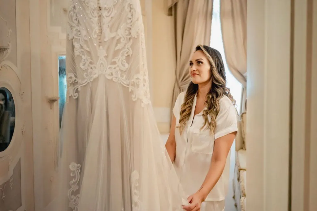Bride and groom hold hands around a corner for their "first touch" moment in a luxurious Venetian hotel.