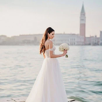 A bride posing elegantly on the banks of San Giorgio Maggiore in Venice – elopement photography Venice.