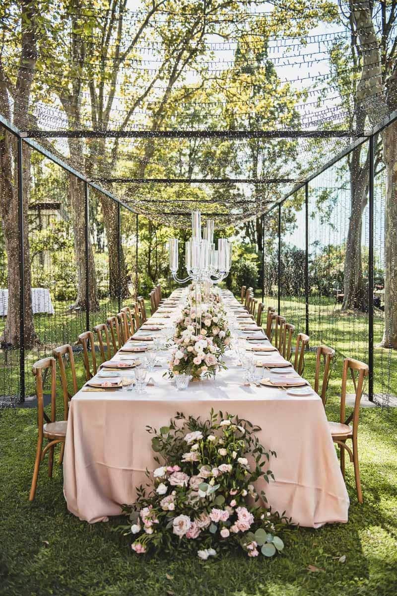Elegant outdoor wedding setup with lush greenery, floral arrangements, and a romantic ambiance.