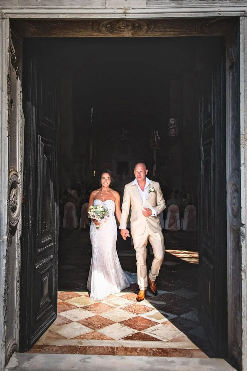 Elegant bride and groom entering a historic venue in Venice for their wedding.