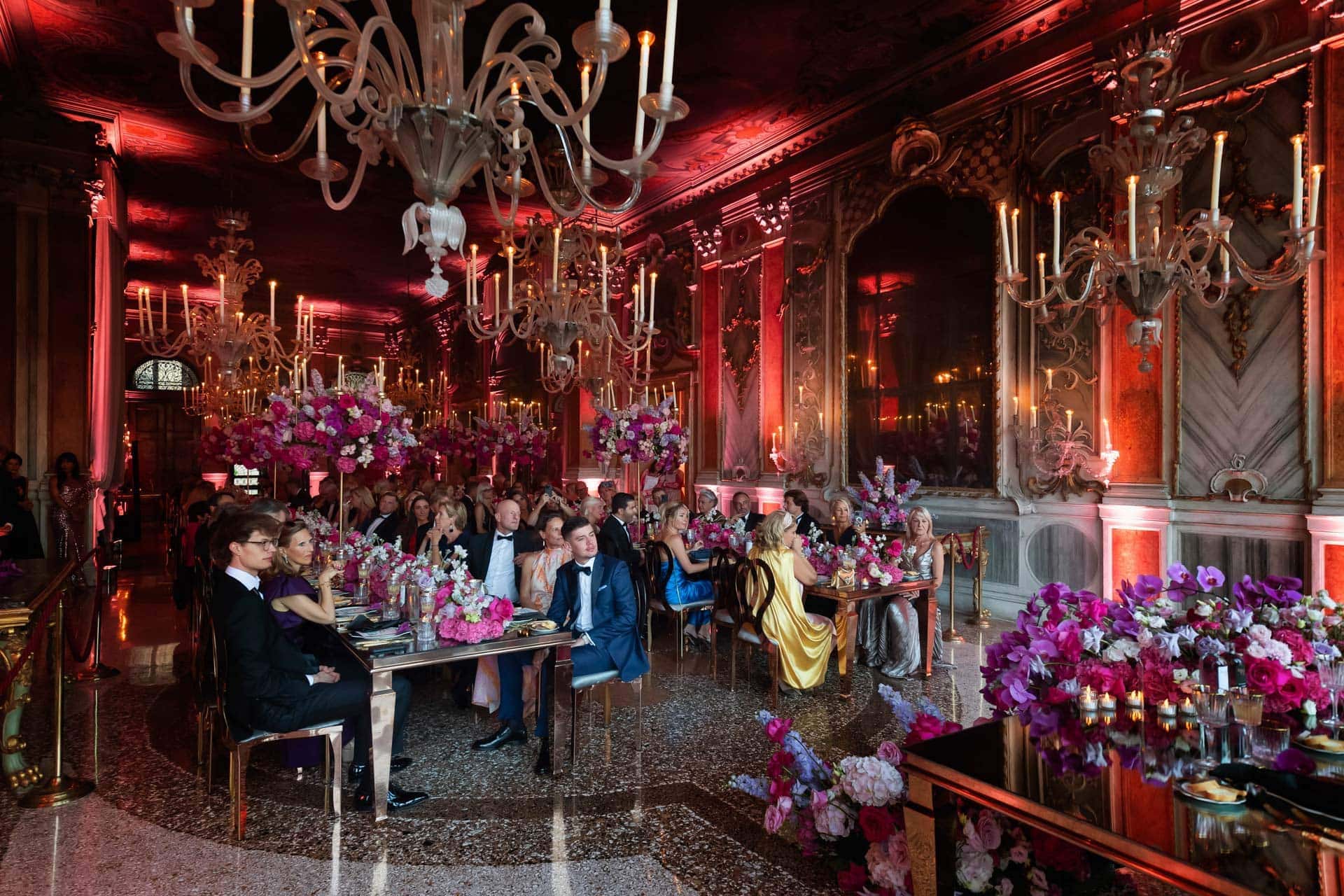 Luxurious wedding reception in an opulent Venetian palace with elegant chandeliers and vibrant floral arrangements.